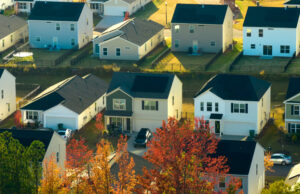 Aerial view of a modern suburban neighborhood with solar-paneled roofs and autumn trees in Virginia.