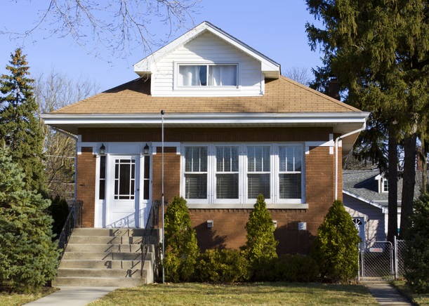 Two-story brick single family home with front lawn and steps